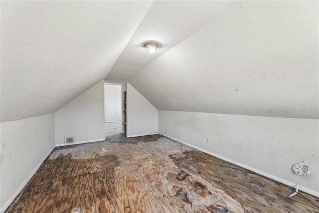 additional living space with visible vents and vaulted ceiling