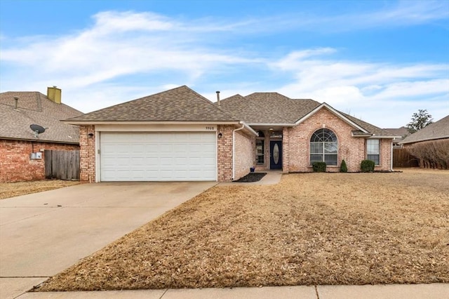 ranch-style home with fence, concrete driveway, a shingled roof, a garage, and brick siding