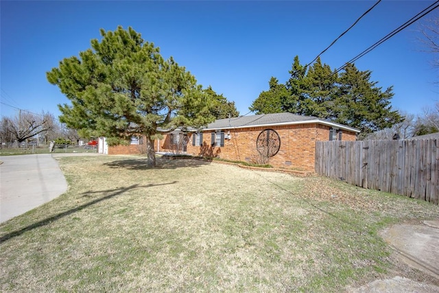 view of front of home featuring crawl space, brick siding, a front lawn, and fence