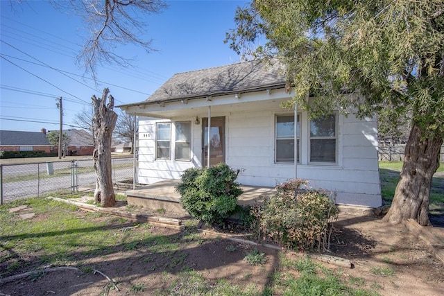 bungalow with a gate, roof with shingles, covered porch, and fence