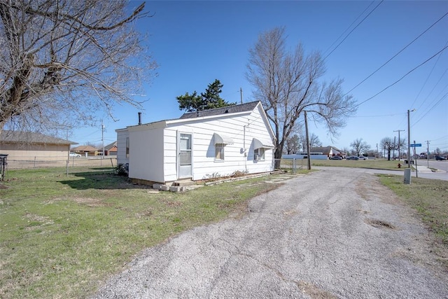 exterior space with driveway, a front lawn, and fence