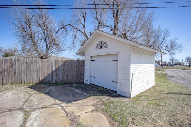 detached garage with fence and driveway