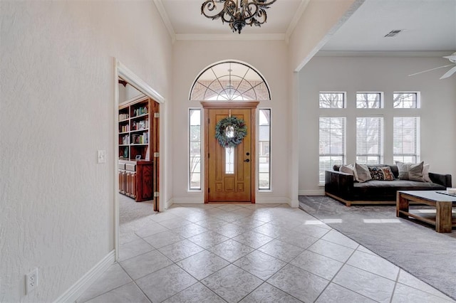 entryway featuring crown molding, a high ceiling, light colored carpet, and visible vents