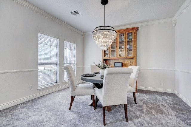 dining space featuring crown molding, baseboards, carpet floors, and a chandelier