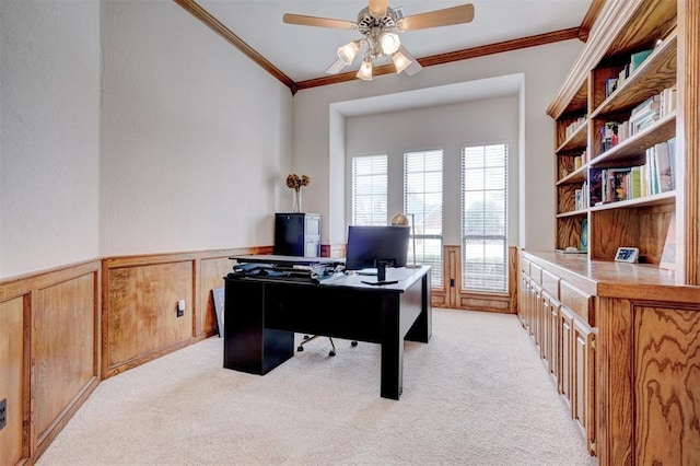 office space featuring ornamental molding, a ceiling fan, a wainscoted wall, and light carpet