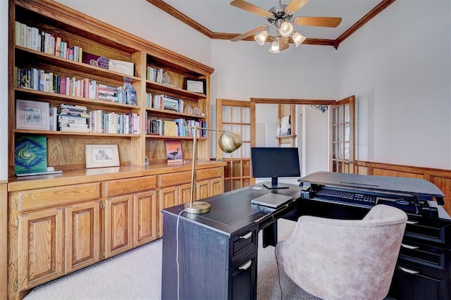 home office with ceiling fan, light colored carpet, a wainscoted wall, and ornamental molding