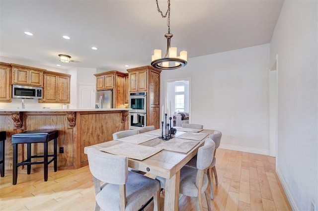 dining room featuring a notable chandelier, recessed lighting, baseboards, and light wood-style floors