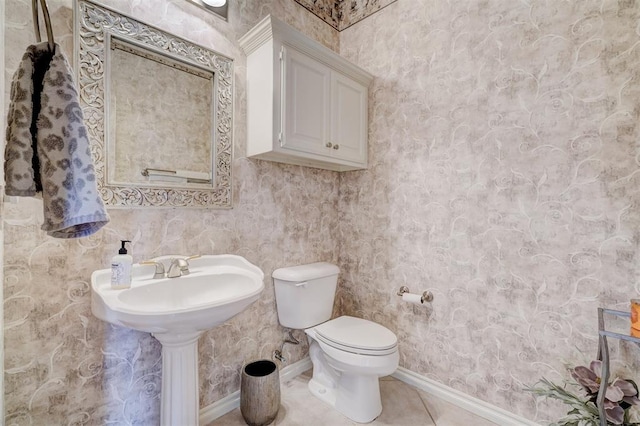 bathroom with tile patterned flooring, toilet, and baseboards