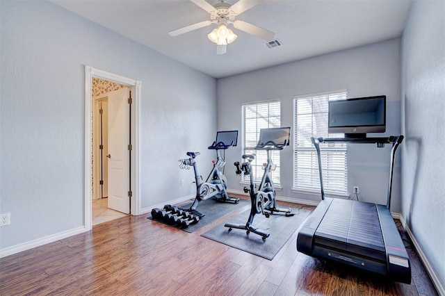 workout room with visible vents, baseboards, ceiling fan, and wood finished floors