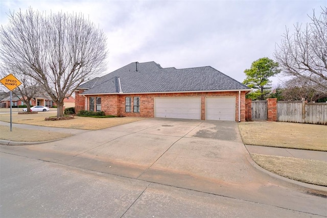 view of front facade with concrete driveway, a garage, fence, and brick siding