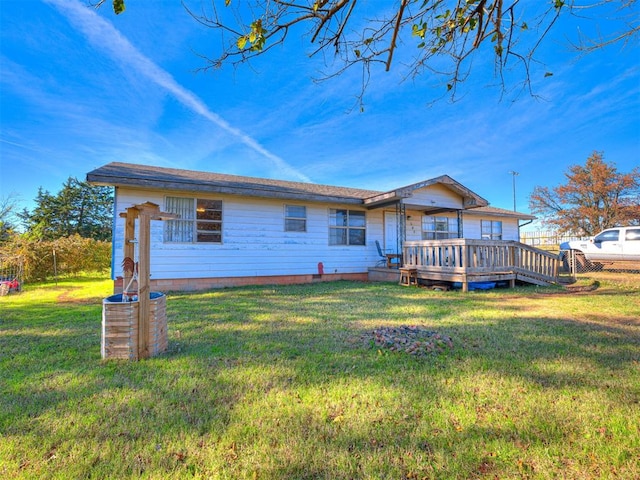 back of house featuring a wooden deck and a yard