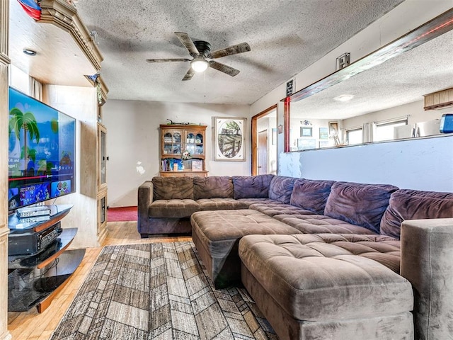 living area with a textured ceiling, wood finished floors, and a ceiling fan