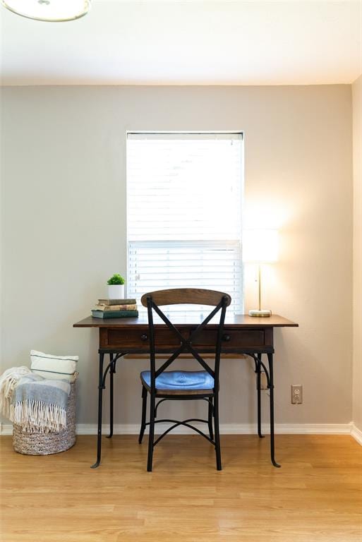 dining area featuring light wood-style flooring and baseboards