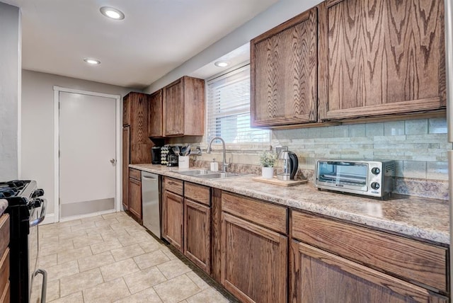 kitchen with a toaster, a sink, stainless steel appliances, light countertops, and backsplash