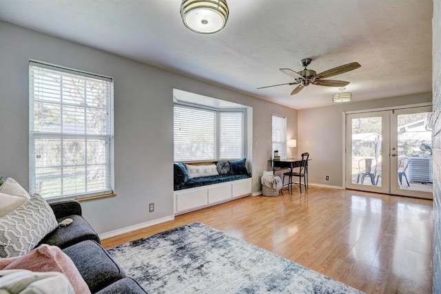 living area with french doors, plenty of natural light, and wood finished floors