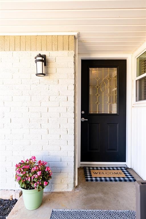 view of exterior entry featuring brick siding