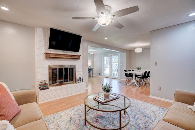 living room featuring recessed lighting, french doors, wood finished floors, and a fireplace