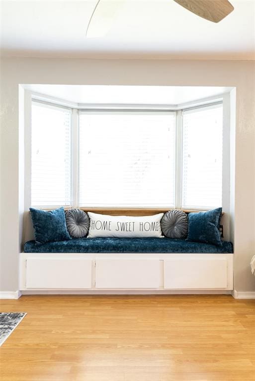 living area with a wealth of natural light, baseboards, and light wood finished floors