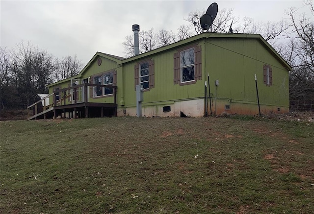 view of side of property with crawl space, a yard, and a deck