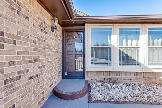 view of exterior entry featuring brick siding