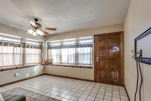 unfurnished sunroom featuring a ceiling fan and a wealth of natural light