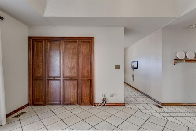 unfurnished bedroom featuring light tile patterned floors, baseboards, and visible vents