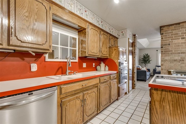 kitchen featuring a sink, stainless steel appliances, light tile patterned flooring, and light countertops