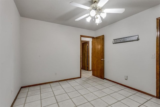 spare room with baseboards and a ceiling fan