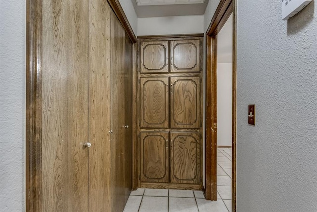 interior space with light tile patterned floors and a textured wall