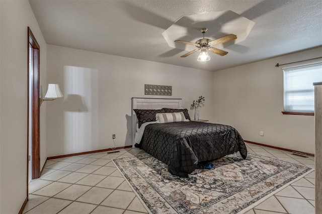 bedroom featuring light tile patterned floors, a textured ceiling, and baseboards