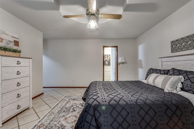 bedroom featuring baseboards, ensuite bath, light tile patterned flooring, and a ceiling fan