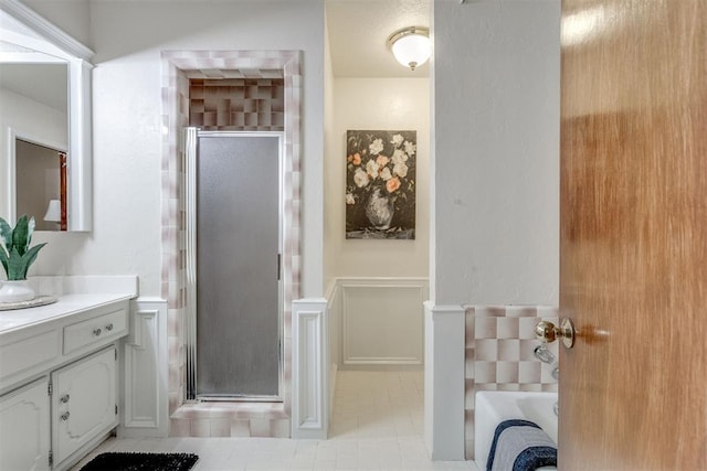 full bath featuring vanity, a shower stall, and a bathing tub