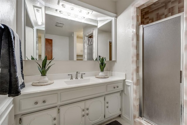 bathroom with visible vents, a stall shower, and vanity