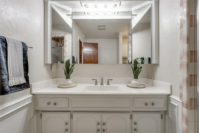 bathroom with vanity and a textured wall