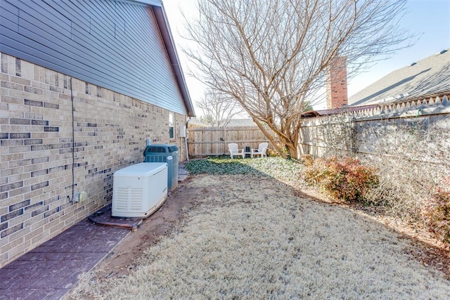 view of yard with central air condition unit and a fenced backyard