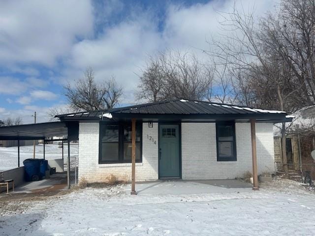 view of front facade with metal roof and brick siding