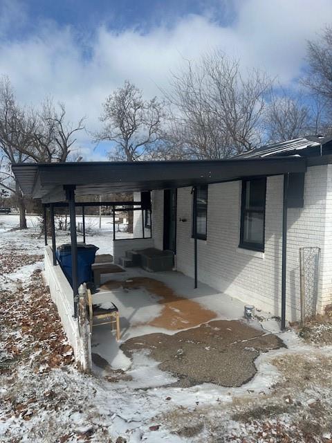 snow covered patio with an attached carport