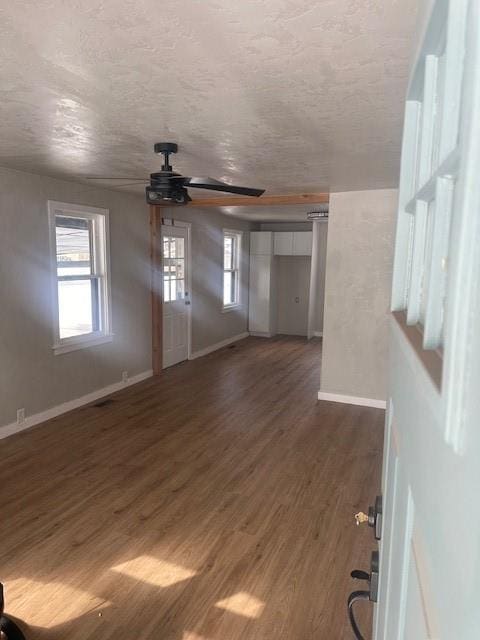 unfurnished room with a ceiling fan, wood finished floors, baseboards, and a textured ceiling