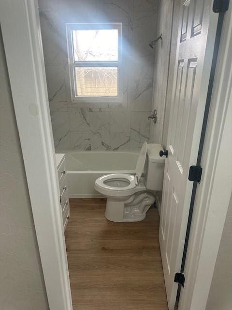 full bath with toilet, shower / washtub combination, and wood finished floors