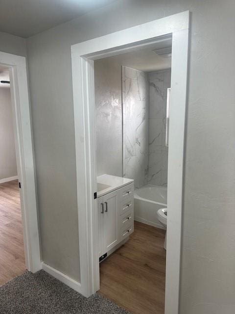 full bathroom featuring vanity, toilet, wood finished floors, and baseboards