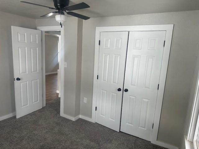1214 E Cleveland Ave, Guthrie, OK 73044 - unfurnished bedroom featuring baseboards, a ceiling fan, a closet, and dark carpet