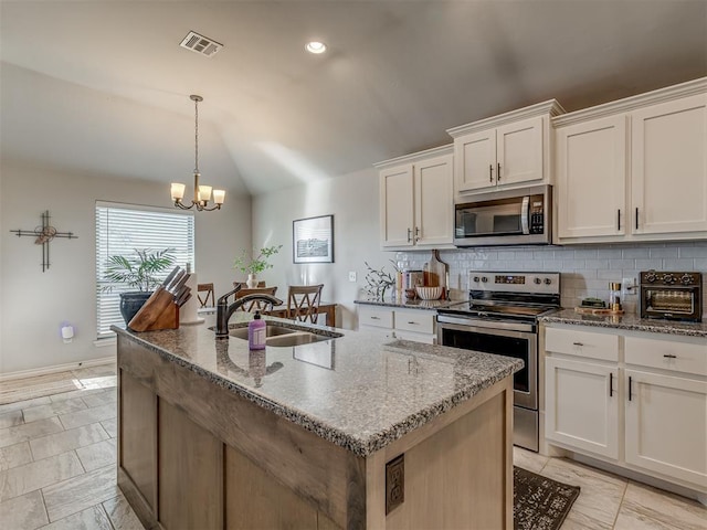 kitchen featuring tasteful backsplash, visible vents, vaulted ceiling, appliances with stainless steel finishes, and a sink