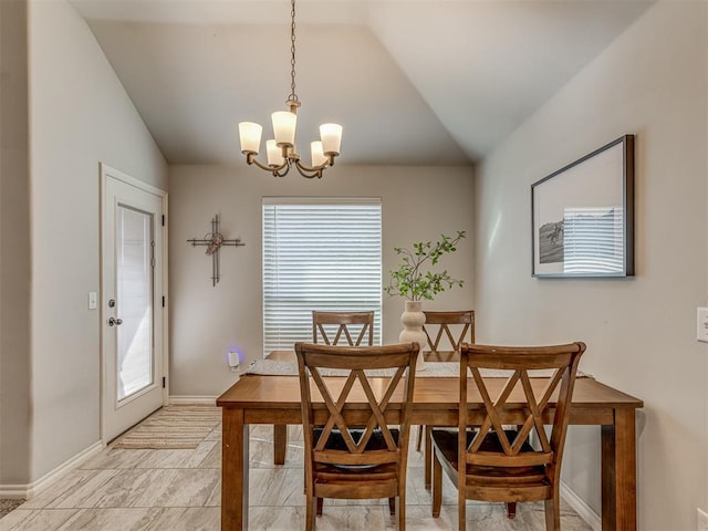 dining space featuring a chandelier, baseboards, and vaulted ceiling