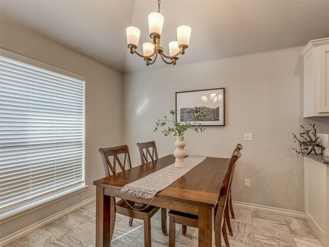 dining area featuring an inviting chandelier and baseboards