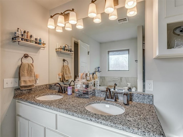 bathroom with a sink, visible vents, and double vanity