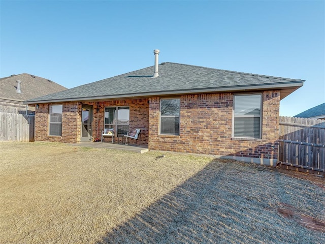 back of property with fence, brick siding, and a shingled roof