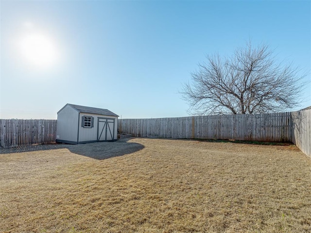 view of yard with an outbuilding, a shed, and a fenced backyard