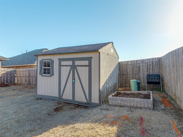 view of shed with a vegetable garden and a fenced backyard