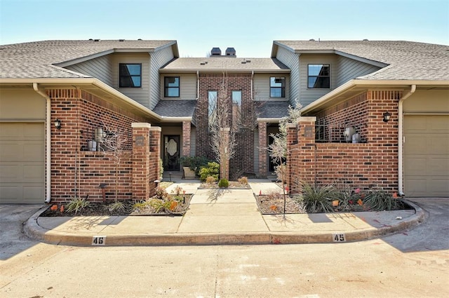 townhome / multi-family property with brick siding and a shingled roof