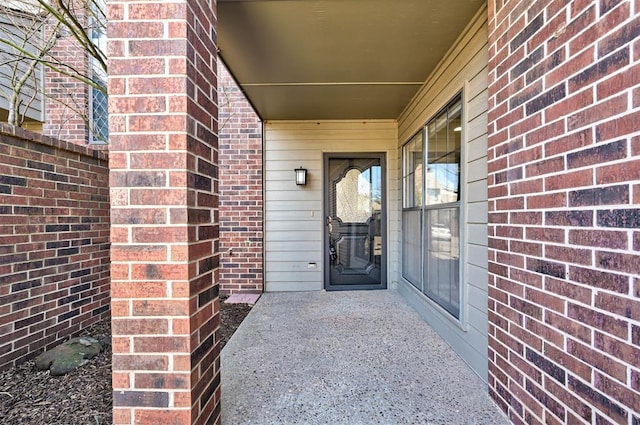 property entrance featuring brick siding